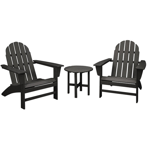 A black POLYWOOD patio set with 2 Adirondack chairs and a side table on an outdoor patio.