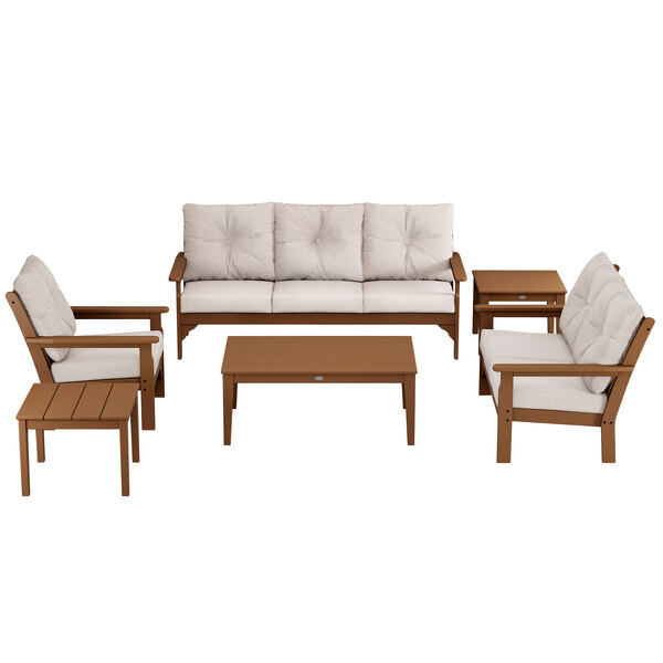 A wooden POLYWOOD patio set with white cushions on a white background.