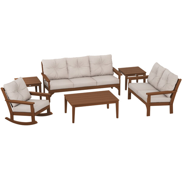 A POLYWOOD wooden patio set with beige cushions on a white background including a couch, rocking chair, and table.