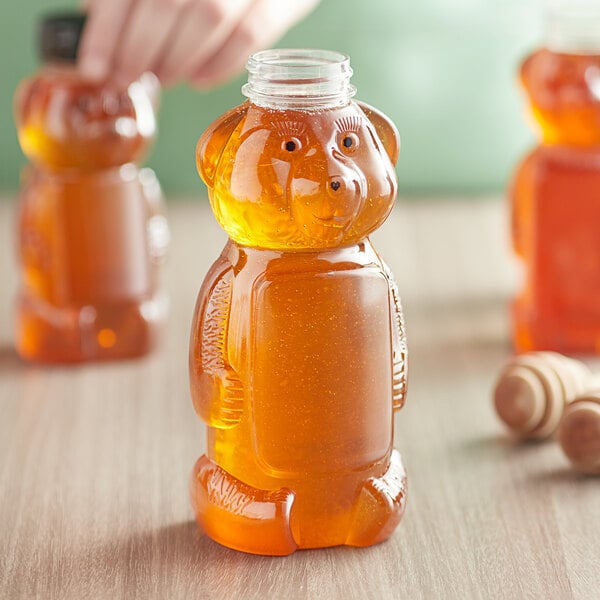 A plastic bear shaped honey bottle with a lid.