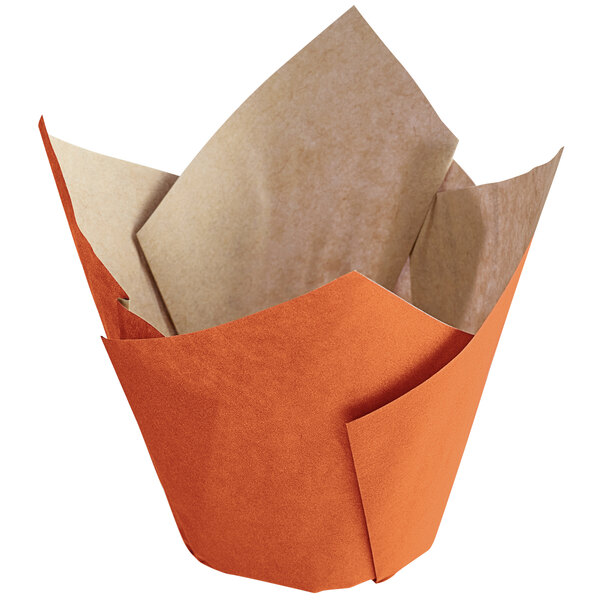 An orange and tan paper baking cup with a white tulip design.