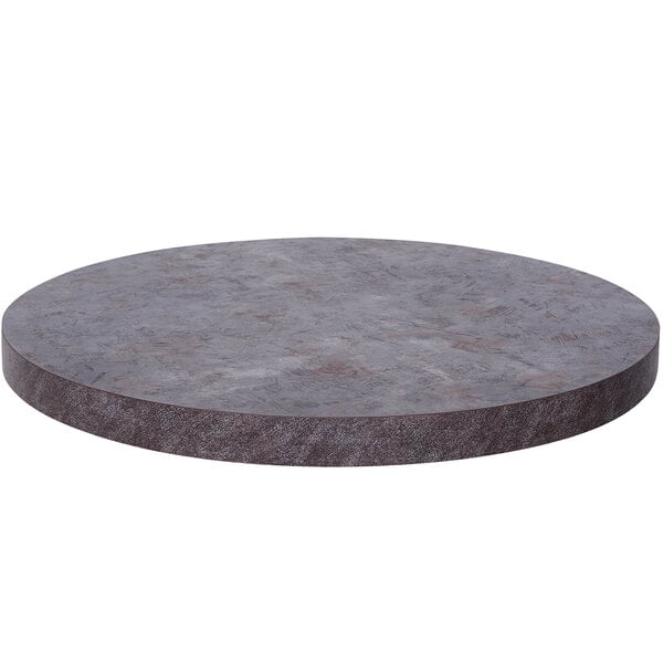 A BFM Seating Relic round copper table top with a gray surface.