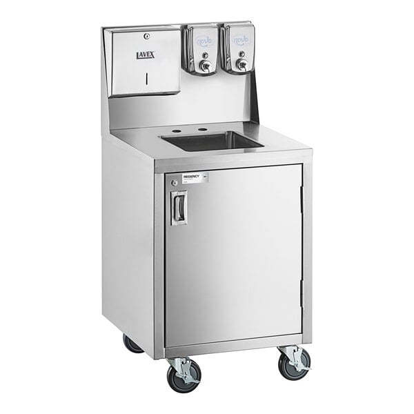 A stainless steel portable hand sink cart with a single bowl, cabinet, paper towel dispenser, and two soap dispensers, mounted on four caster wheels.