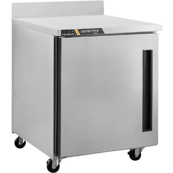 A Traulsen stainless steel worktop freezer with a left hinged door on wheels.