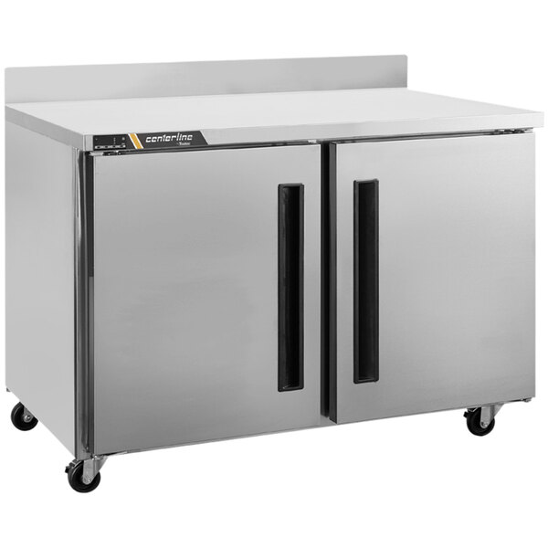 A silver Traulsen worktop freezer with two left hinged doors on wheels.