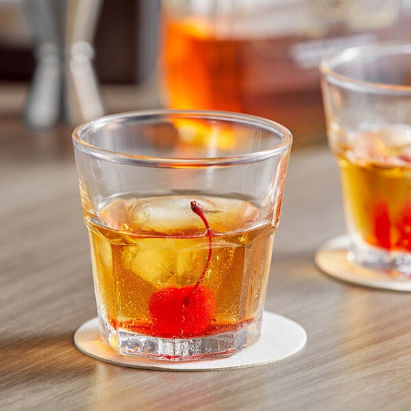 Two Acopa Memphis old fashioned glasses with cherries and ice cubes.
