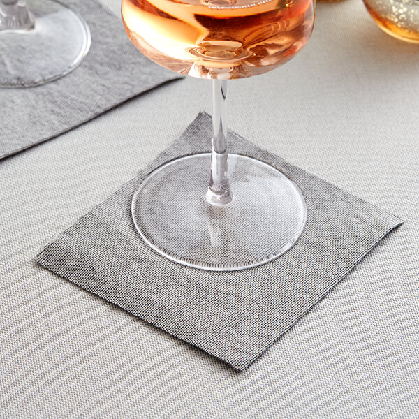 A glass of wine on a Hoffmaster Natural Onyx Linen-Like beverage napkin.
