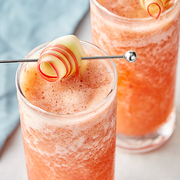 Two glasses of pink rhubarb fruit puree with straws.