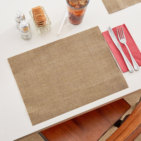 A Hoffmaster burlap print placemat on a table with a glass of ice.