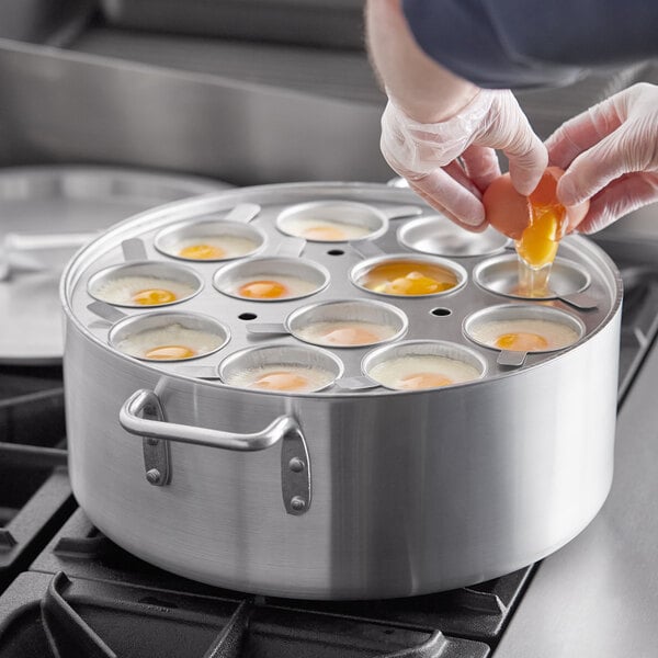 A person using a Choice 12-Cup Egg Poacher Set to cook eggs in a large pan.