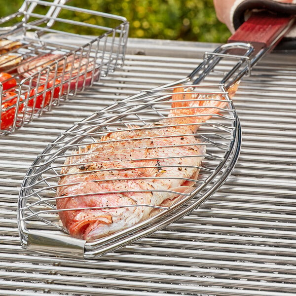 A Outset fish grill basket on a grill over a flame.