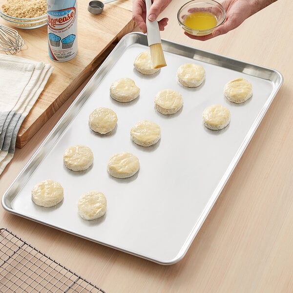 A person using a Choice aluminum bun/sheet pan to bake cookies.