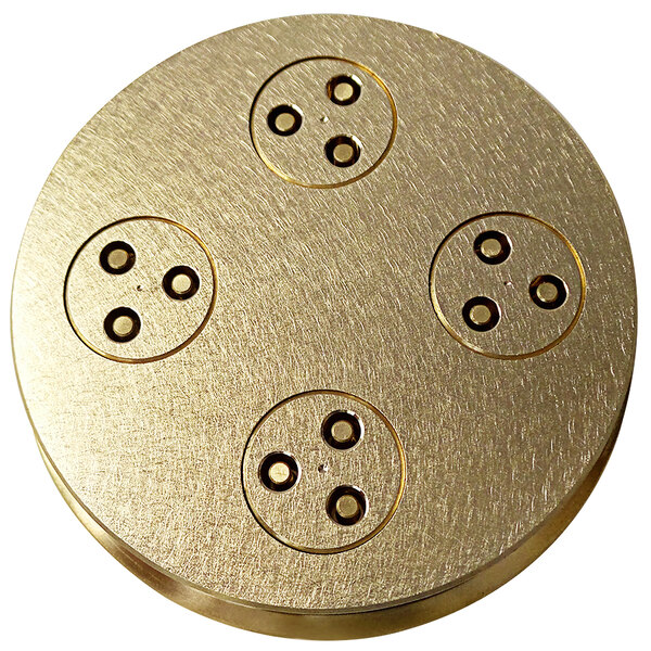 A circular brass plate with four holes in it.
