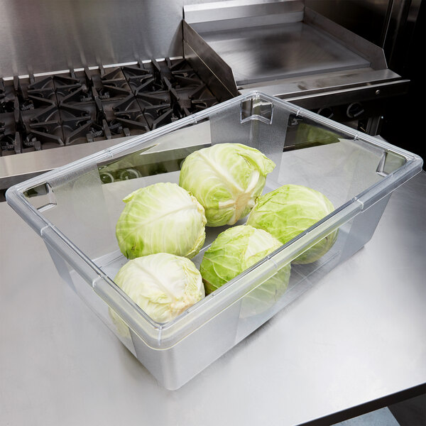 A Carlisle clear plastic food storage container with cabbages in it.