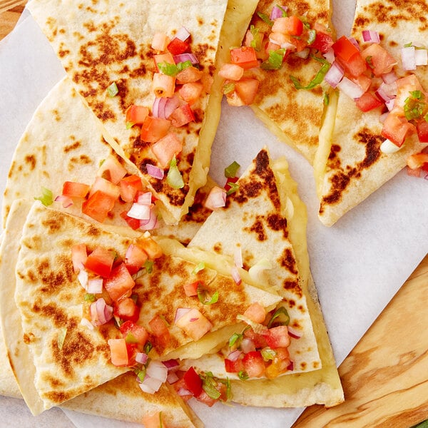 A quesadilla with V&V Supremo Chihuahua Queso cheese, tomatoes, and onions.