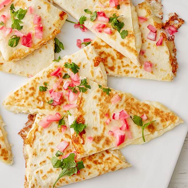 A plate of quesadillas with V&V Supremo grated Mexican 3-cheese blend served with vegetables.