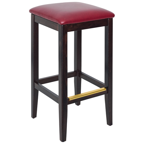 A dark walnut beechwood backless bar stool with a burgundy vinyl seat.
