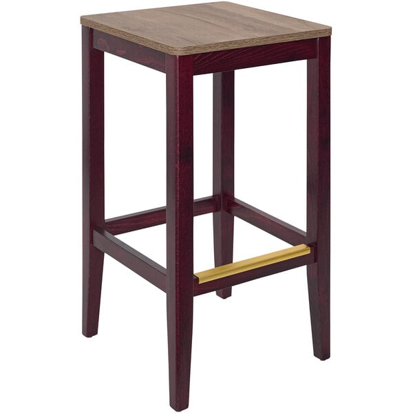 A BFM Seating dark mahogany wooden backless barstool with a wooden seat.
