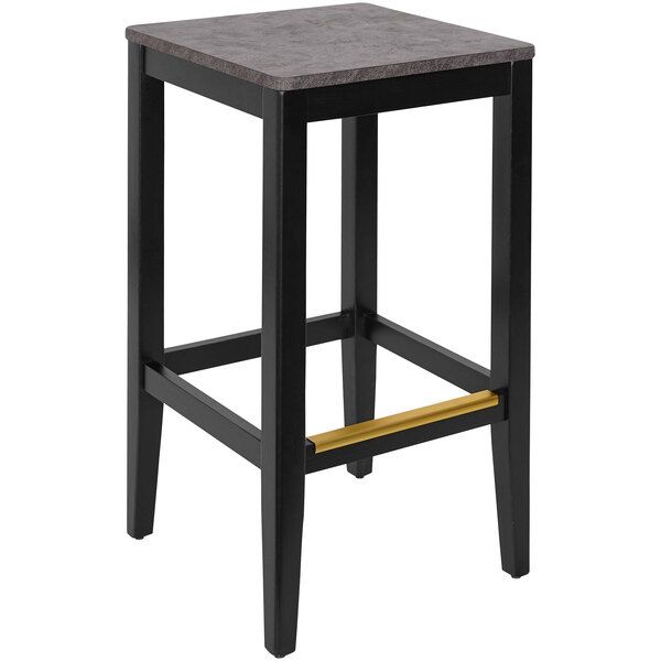 A black BFM Seating bar stool with a wooden seat on a bar table.
