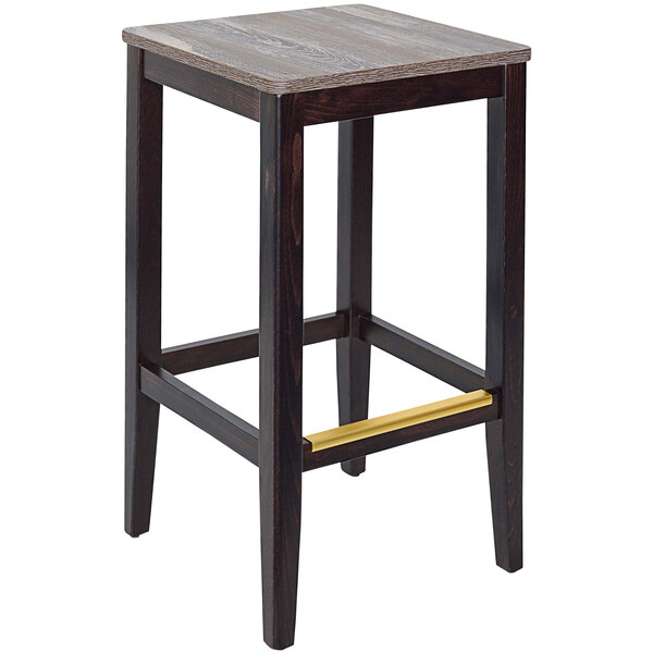 A BFM Seating dark walnut beechwood bar stool with a wooden seat.