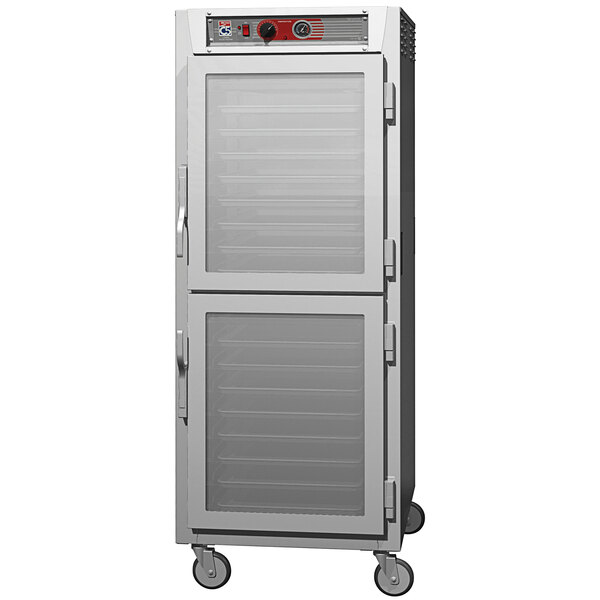 A stainless steel Metro holding cabinet with clear Dutch doors and aluminum lip load slides.