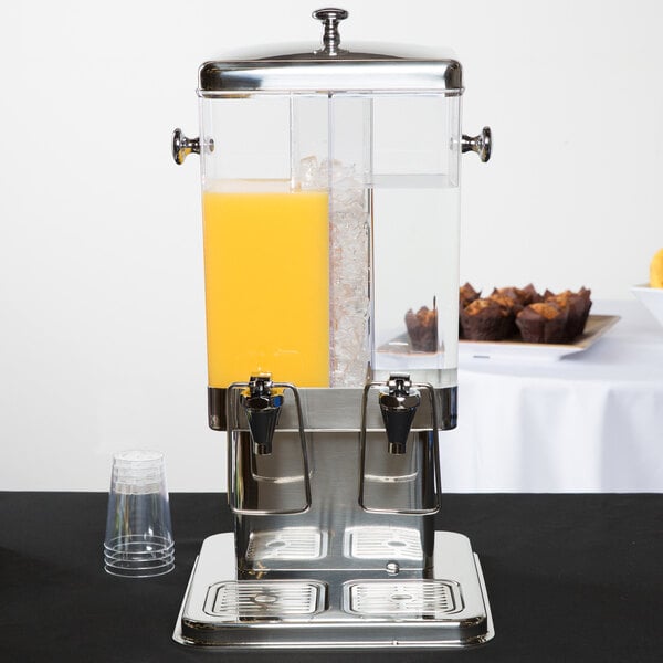 A Tablecraft plastic beverage dispenser with orange juice and orange slices in it.