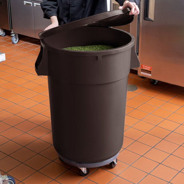 A woman opening a large black Mobile Ingredient Storage Bin with a lid.