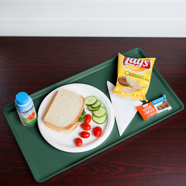A Cambro Sherwood Green dietary tray with a sandwich and vegetables.