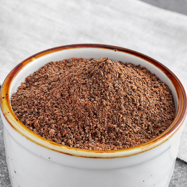 A white bowl of brown Regal Cowboy Coffee Rub powder.