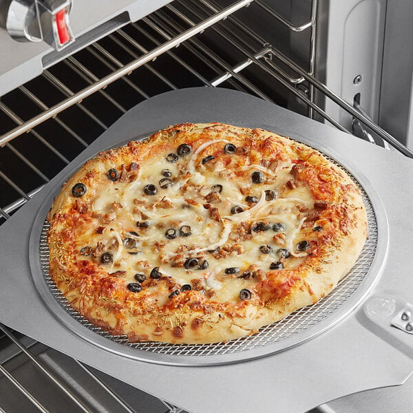 A Choice aluminum pizza screen with a pizza cooking in an oven.