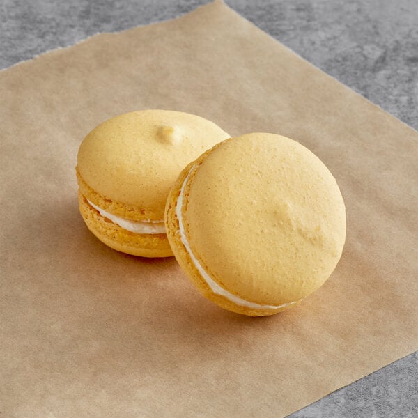 Two Macaron Centrale Almond Overload macarons on a piece of paper.