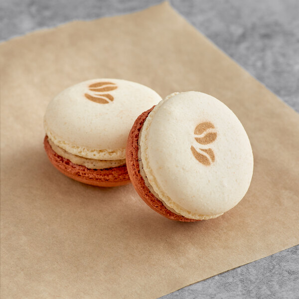 Two vanilla latte macarons on a paper.