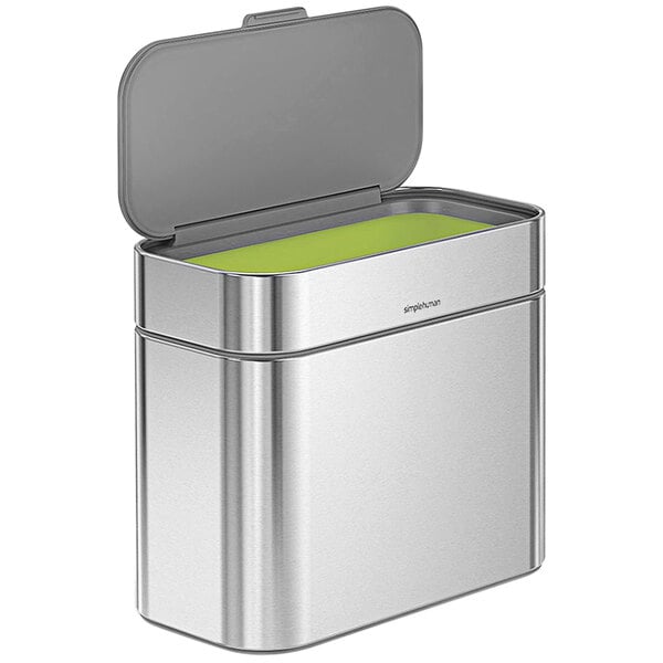 A brushed stainless steel compost caddy with a green lid.