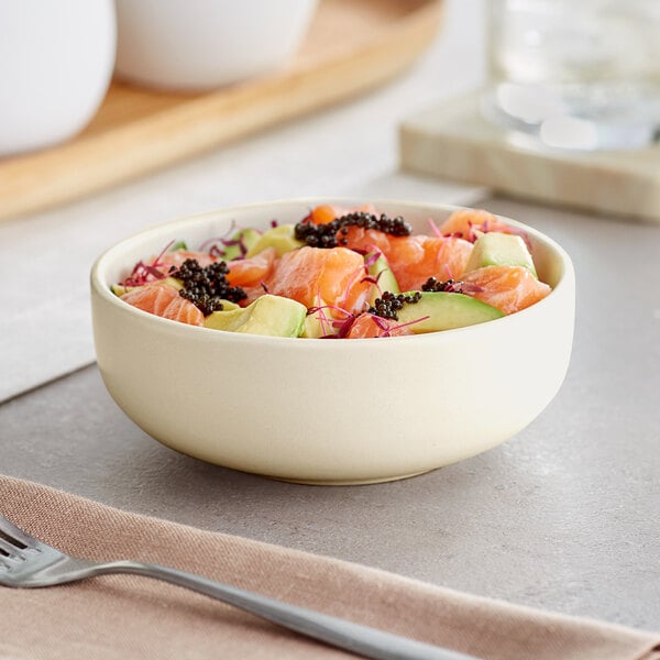 A close-up of a white Acopa Pangea nappie bowl filled with a salmon and avocado salad.