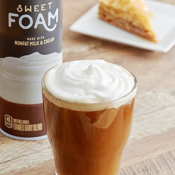 A glass of coffee with Reddi-Wip Sweet Foam next to a bottle of milk.