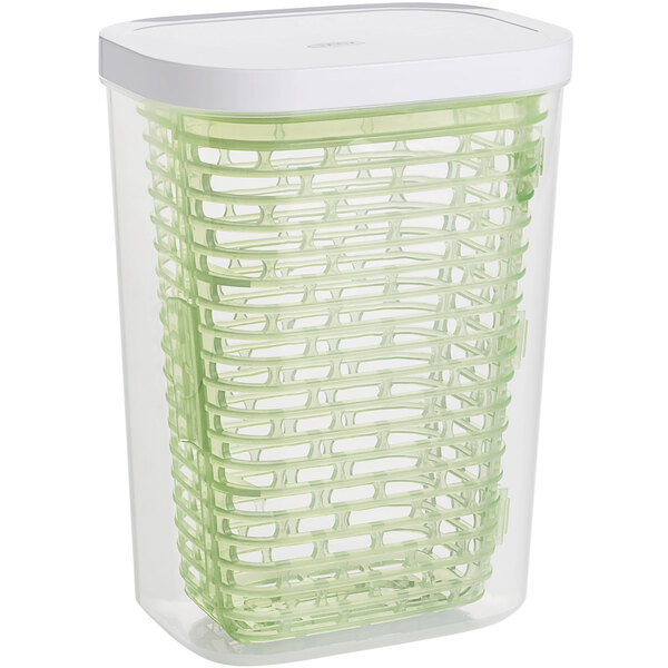 A clear plastic OXO herb keeper with a white lid.