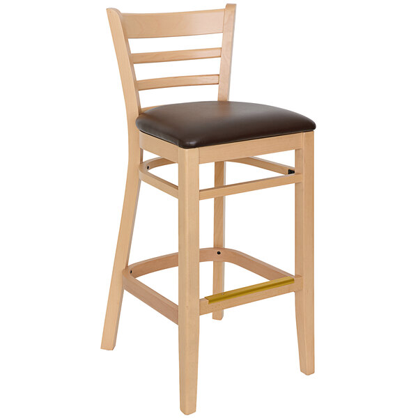 A BFM Seating wooden ladder back barstool with a black vinyl cushion.