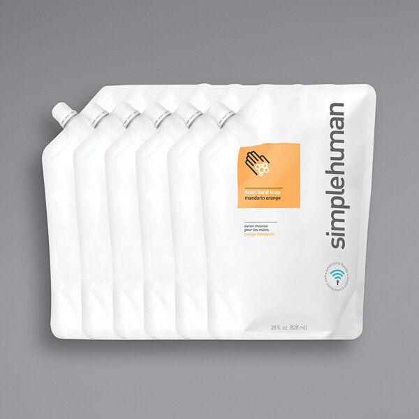 A group of white plastic bags with orange and black labels for simplehuman Mandarin Orange scented foam hand soap refill.