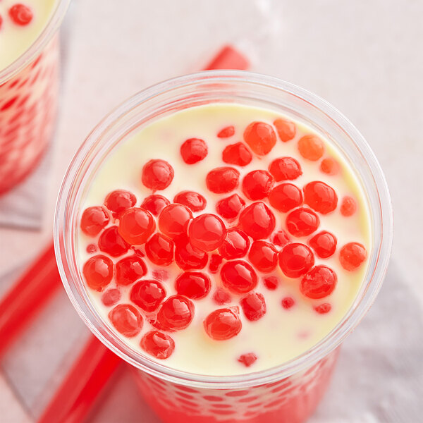 A cup of red bubble tea with Fanale Strawberry Popping Boba.