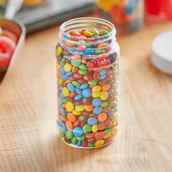 A clear round PET jar filled with colorful candy.