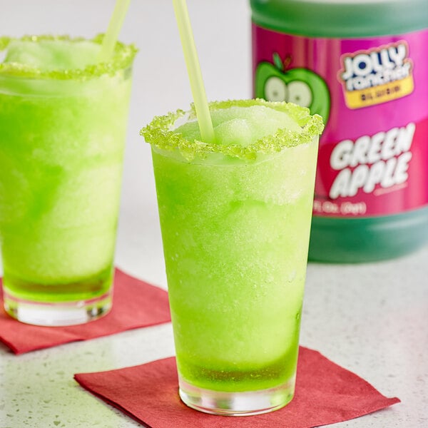 A glass of green Jolly Rancher Green Apple slushy with ice and mint.