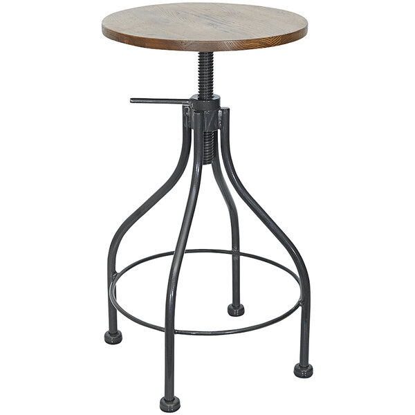 A BFM Seating black steel backless barstool with a wood seat on a table with metal legs.