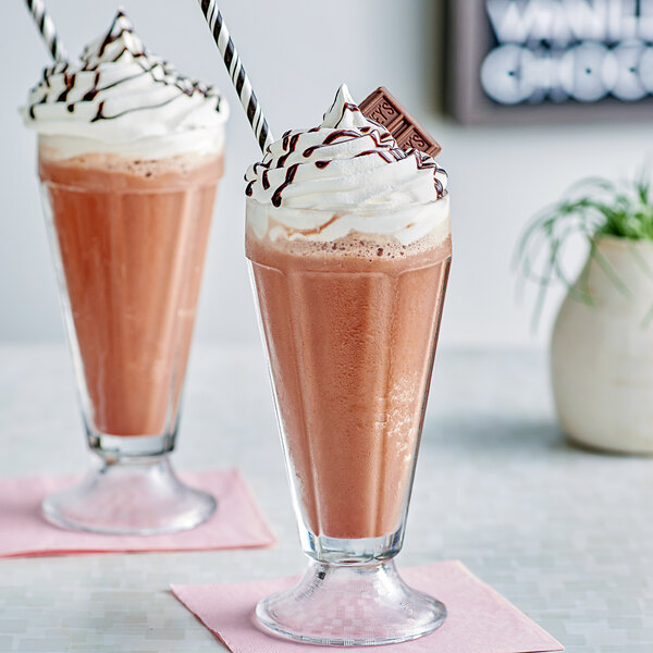 A close-up of two glasses of Hershey's chocolate milkshakes with straws.