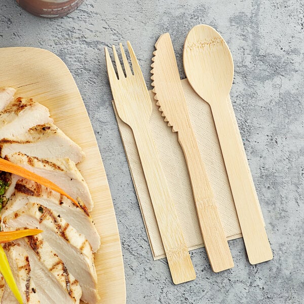A HAY! cutlery pack with a wooden fork and spoon on a white surface.