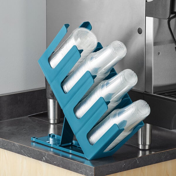 A blue Choice countertop cup and lid organizer with plastic cups in it.