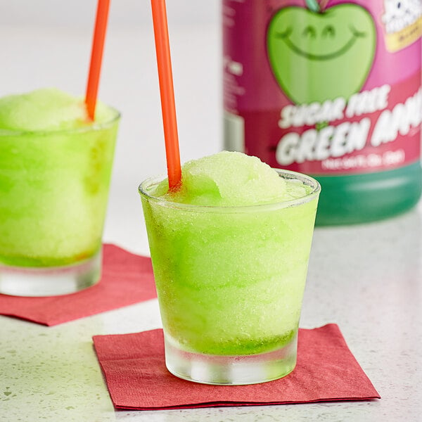 A glass of green Jolly Rancher Sugar Free Green Apple slushy with a straw.