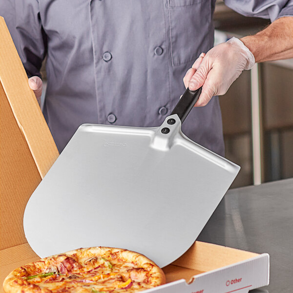 A man holding a GI Metal rectangular pizza peel in a box.