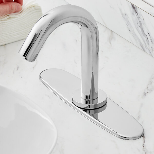 A silver Waterloo faucet deck plate installed on a marble counter.