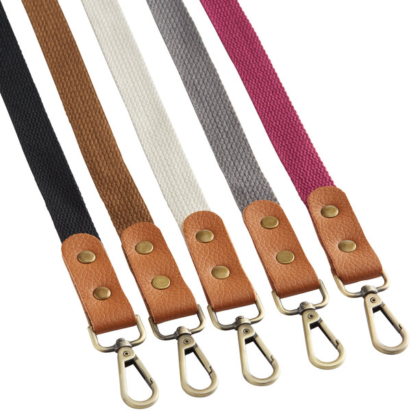 A close-up of cream leather Acopa Hazleton cross-back straps with brass buckles.