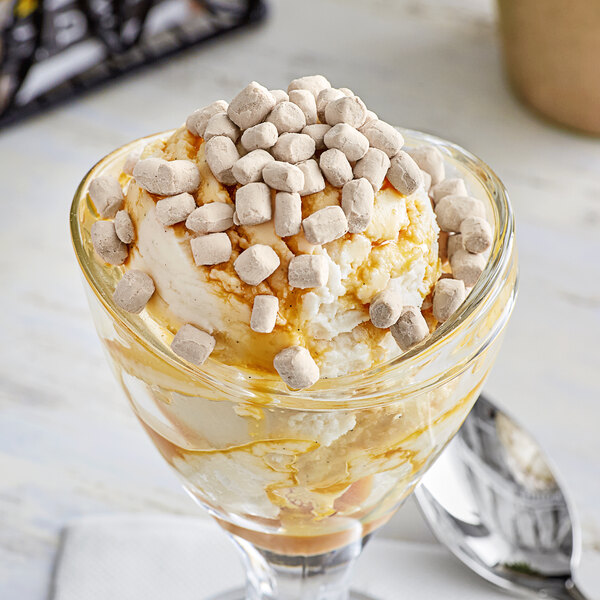 A glass of ice cream topped with marshmallows and chocolate dehydrated marshmallow topping.